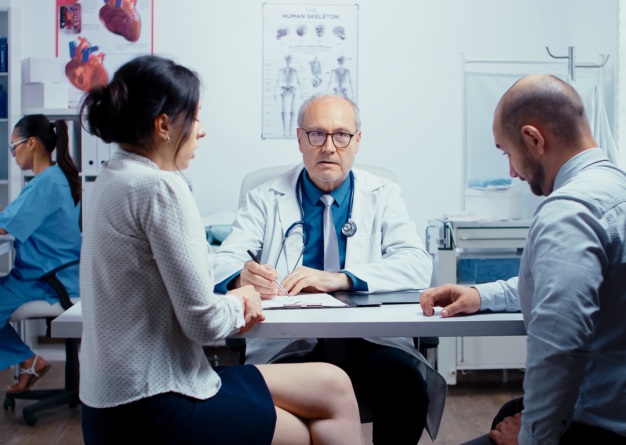 A couple talks with a doctor at the hospital about their loved one experiencing a mental health crisis.